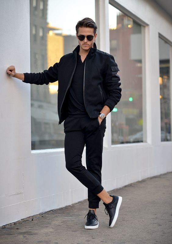 A stylish man sporting a navy bomber jacket over a white t-shirt for a casual yet sophisticated look.